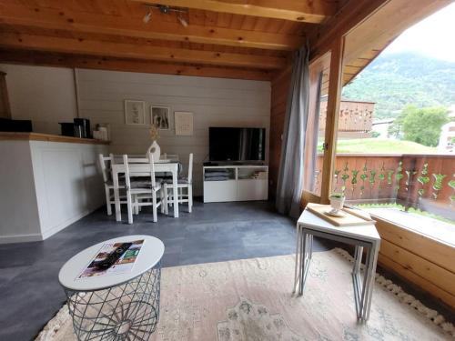 Cette chambre comprend une cuisine et une salle à manger avec une table. dans l'établissement Charmant Appartement Bozel Centre, à Bozel