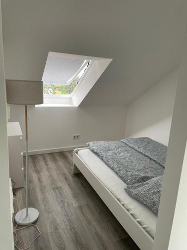 a white bedroom with a bed and a window at Wohnung im Gästehaus in Bernau bei Berlin