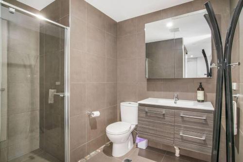 a bathroom with a toilet and a shower and a sink at The Zen Apartments with Urban Soul in Adelaide