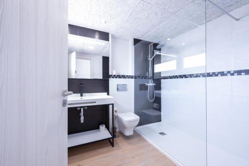 uma casa de banho com um WC, um lavatório e um chuveiro em Hotel Costa Brava em Roses