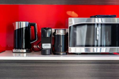 a microwave and other appliances on a shelf at The Zen Apartments with Urban Soul in Adelaide
