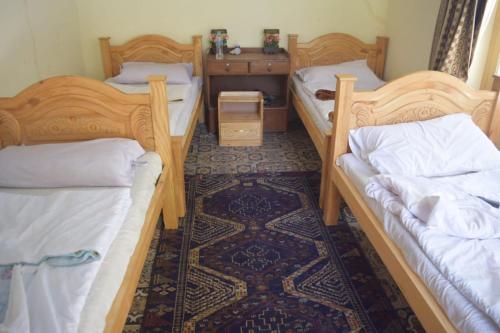 Chitral Green Guest House في شيترال: غرفة بسريرين بطابقين وطاولة