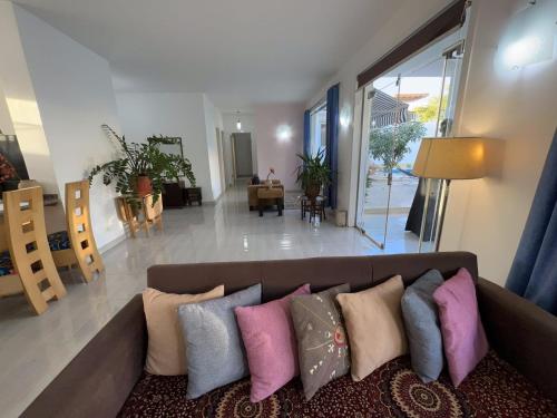 Luxor Rose Villa في الأقصر: غرفة معيشة مع أريكة مع وسائد ملونة