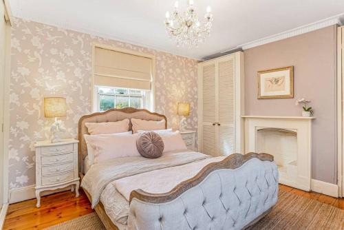 a bedroom with a large bed and a chandelier at Firebird Cottage A Hallmark to Adelaides History in Bowden