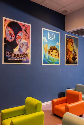 a waiting room with two chairs and posters on the wall at C Hotel Neve Ilan in Neve Ilan