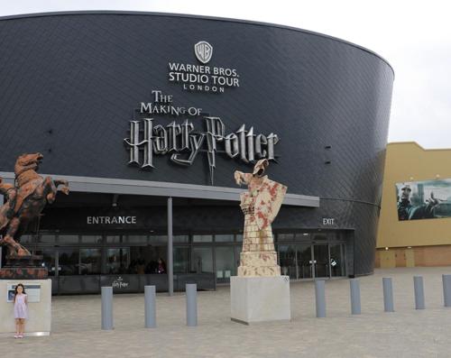 a large building with a statue in front of it at Warner Brothers Apartment in Watford