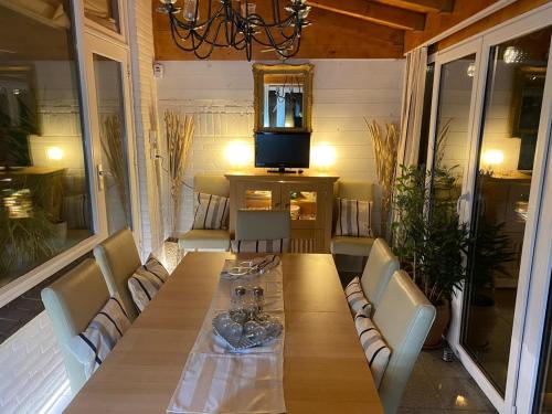 Weltevree في تيخيلين: طاولة خشبية مع كراسي وتلفزيون على شرفة