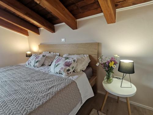 Apartment Harmony في بال: غرفة نوم بسرير وطاولة مع إناء من الزهور