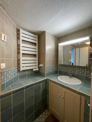 a bathroom with a sink and a mirror at Appartement Duplex Climatisé Le Trident in Saintes-Maries-de-la-Mer