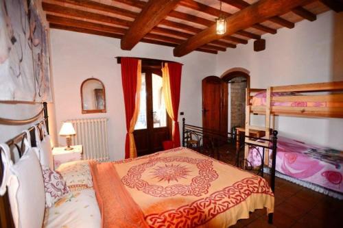 una camera con un letto e due letti a castello di Villa Podere Antico con piscina a Civitella Del Lago