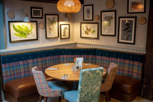a dining room with a wooden table and chairs at Berkshire Arms by Chef & Brewer Collection in Midgham
