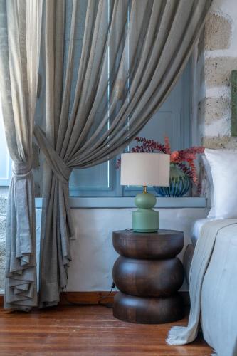 a bedroom with a bed and a table with a lamp at Alaçatı Taş Otel in Alacati
