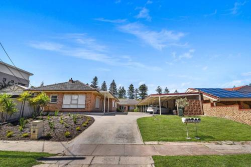 a home in a suburb with a driveway at Beachy Keen in Gorgeous Henley Beach in Henley Beach