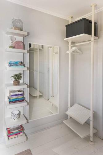 a room with white shelves and a mirror at Beachy Keen in Gorgeous Henley Beach in Henley Beach