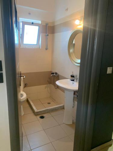 a bathroom with a sink and a toilet and a mirror at chris house in Kalamata