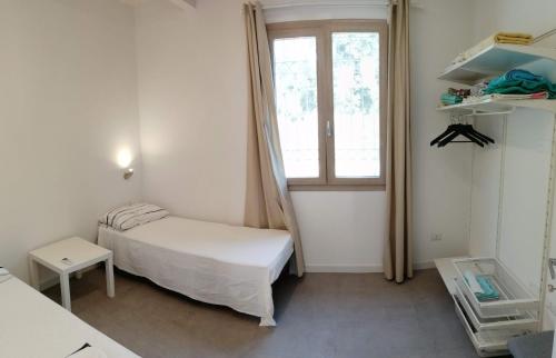 - une petite chambre avec un lit et une fenêtre dans l'établissement Dépendance con giardino fronte mare, à Alghero