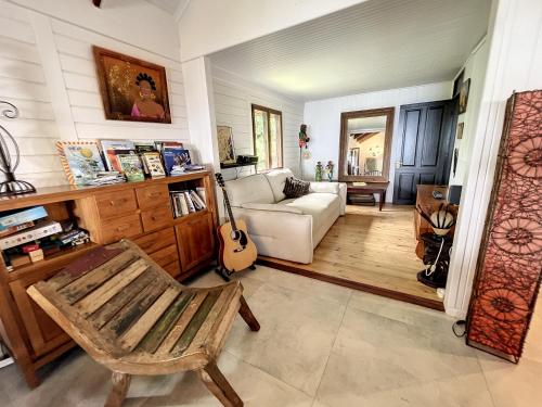 Una sala de estar con una silla y una guitarra. en Maison camomille, en Le Cap