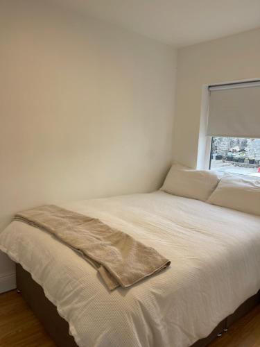 a white bed in a room with a window at Peacock Farms Estate in Cork