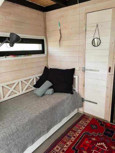 1 dormitorio con 1 cama en una habitación de madera con puerta en Kalana Kapteni Beach House en Kalana