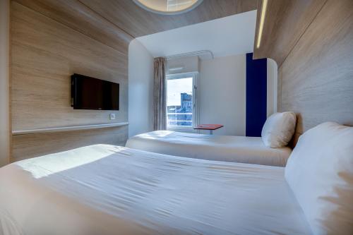 une chambre d'hôtel avec deux lits et une télévision dans l'établissement ibis Styles La Rochelle Centre, à La Rochelle