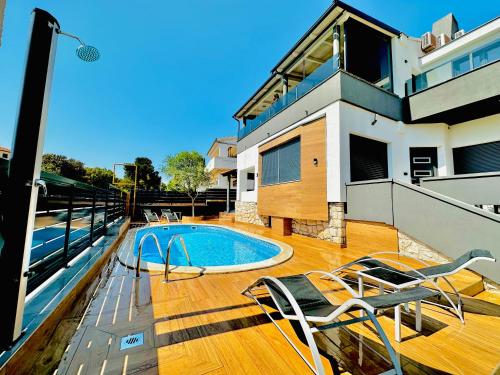 a house with a swimming pool on a wooden deck at NOEL - three bedroom apartment with pool in Banjole