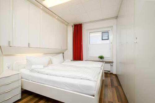ブラウンラーゲにあるFewo Haudeの小さなベッドルーム(白いベッド1台、窓付)