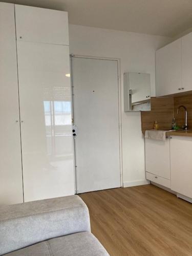 a kitchen with a sliding door in a room at Charmant Studio à Boulogne Nord proche porte d'Auteuil in Boulogne-Billancourt