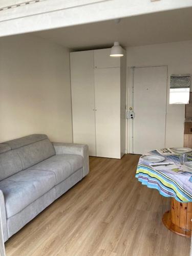 ein Wohnzimmer mit einem Sofa und einem Tisch in der Unterkunft Charmant Studio à Boulogne Nord proche porte d'Auteuil in Boulogne-Billancourt