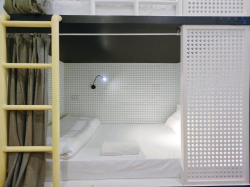a small white bunk bed in a room at Ostay Asoke Bangkok in Makkasan