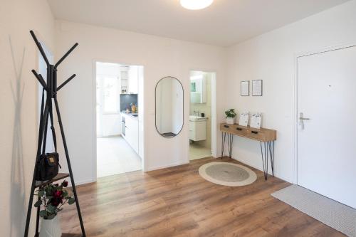 a white room with a mirror and a wooden floor at STAYY Bijou Balgrist nahe Spital - gratis Parkplatz in Zürich