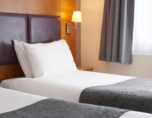 a hotel room with two beds and a window at De Trafford Arms by Chef & Brewer Collection in Alderley Edge
