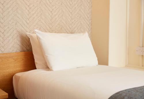 a white pillow sitting on top of a bed at De Trafford Arms by Chef & Brewer Collection in Alderley Edge