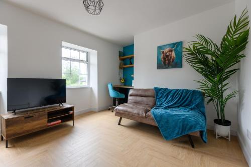 ein Wohnzimmer mit einem TV, einem Sofa und einer Anlage in der Unterkunft Monk Street Apartments by Abergavenny 3-Peak Properties in Abergavenny