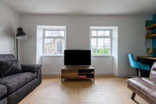 a living room with a couch and a tv on a table at Monk Street Apartments by Abergavenny 3-Peak Properties in Abergavenny