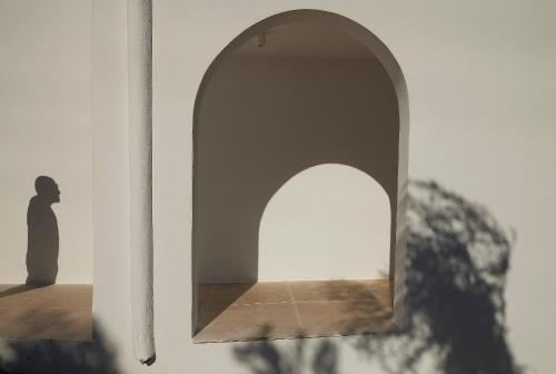 an archway in a white wall with a silhouette at Once in Mykonos - Designed for Adults in Ornos