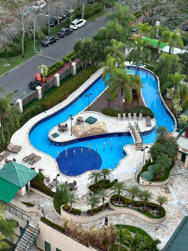 an overhead view of a pool at a resort at Flat com Vista Panorâmica -15- na Barra da Tijuca - Estacionamento Gratuito - Frigobar - Ar condicionado - Piscina - Academia - Balsa para Praia Grátis - Varanda - Vista Parcial Mar e Lagoa in Barra da Tijuca