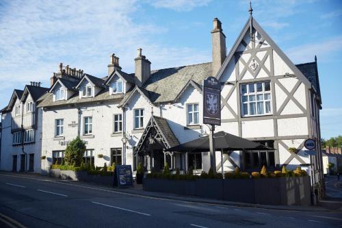 a large white building on the side of a street at De Trafford Arms by Chef & Brewer Collection in Alderley Edge