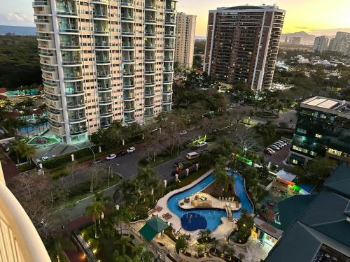 an aerial view of a pool in a city with tall buildings at Flat com Vista Panorâmica -15- na Barra da Tijuca - Estacionamento Gratuito - Frigobar - Ar condicionado - Piscina - Academia - Balsa para Praia Grátis - Varanda - Vista Parcial Mar e Lagoa in Barra da Tijuca