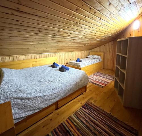 a large wooden room with two beds in it at Casuta noastra din Predeal in Predeal