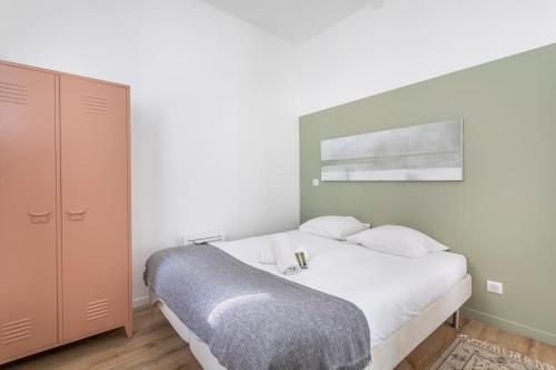 - une chambre avec un lit blanc et une armoire rose dans l'établissement Cosy appartement au coeur du cours Julien, à Marseille