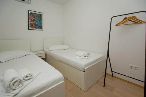 a small bedroom with two beds and a mirror at Luka's Lodge Guesthouse & Hostel in Hvar