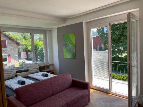 a living room with a couch and large windows at my Relaxs little Villa in Bludenz