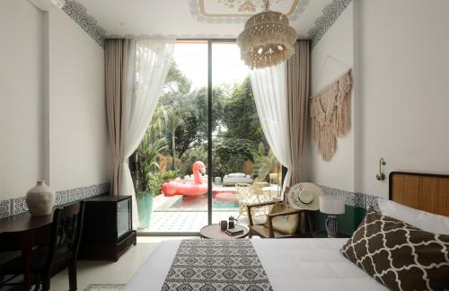 a bedroom with a bed and a view of a pool at The Mansion Hoi An by Minova in Hoi An