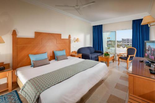 a hotel room with a large bed and a television at Occidental Marco Polo in Hammamet