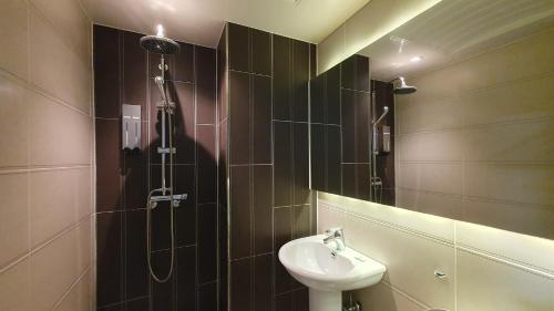 La salle de bains est pourvue d'une douche, d'un lavabo et d'un lavabo. dans l'établissement Hostel Korea - Changdeokgung, à Séoul
