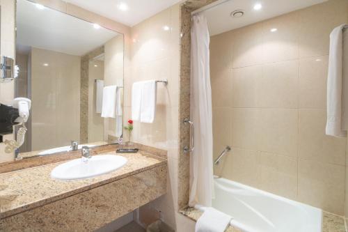 a bathroom with a sink and a tub and a toilet at Concorde Marco Polo in Hammamet