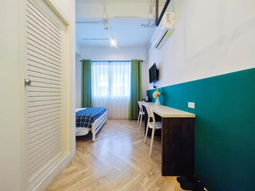 a room with a desk and a table in a room at Ostay Asoke Bangkok in Makkasan