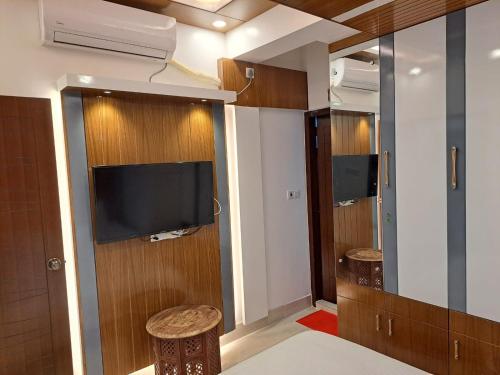 a room with a tv and two stools at The Castle Inn in Dhaka