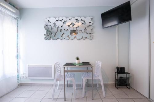 ein Esszimmer mit einem Tisch und Stühlen sowie einem TV in der Unterkunft The Anatole - Cosy & calm apartment in Villeurbanne