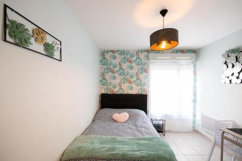 ein Schlafzimmer mit einem Bett mit einem Herzkissen drauf in der Unterkunft The Anatole - Cosy & calm apartment in Villeurbanne